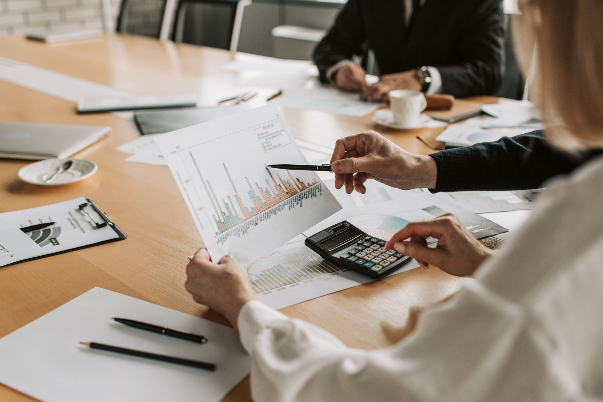 Reunión de asesoría contable con gráficos financieros y calculadora